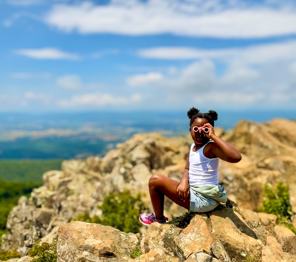 child sitting on mountain 